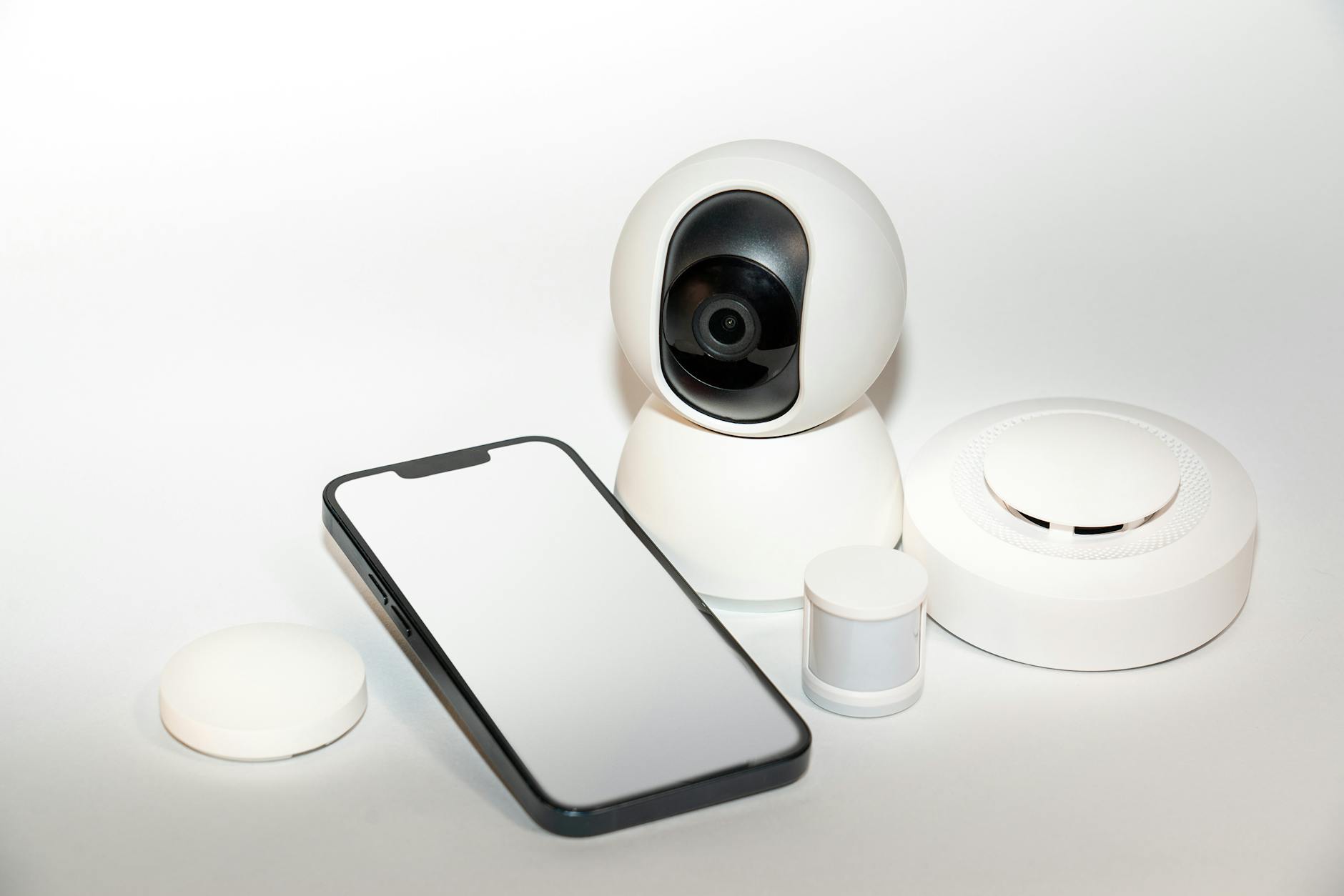 Zestaw urządzeń smart home z widocznym ekranem smartfona