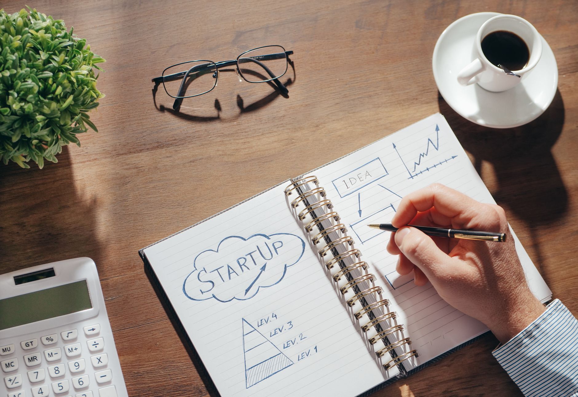 Security by design w startupie: proste praktyki, które oszczędzą ci kryzys PR i kary Biurko startupu z notatnikiem do planowania, okularami i kubkiem kawy