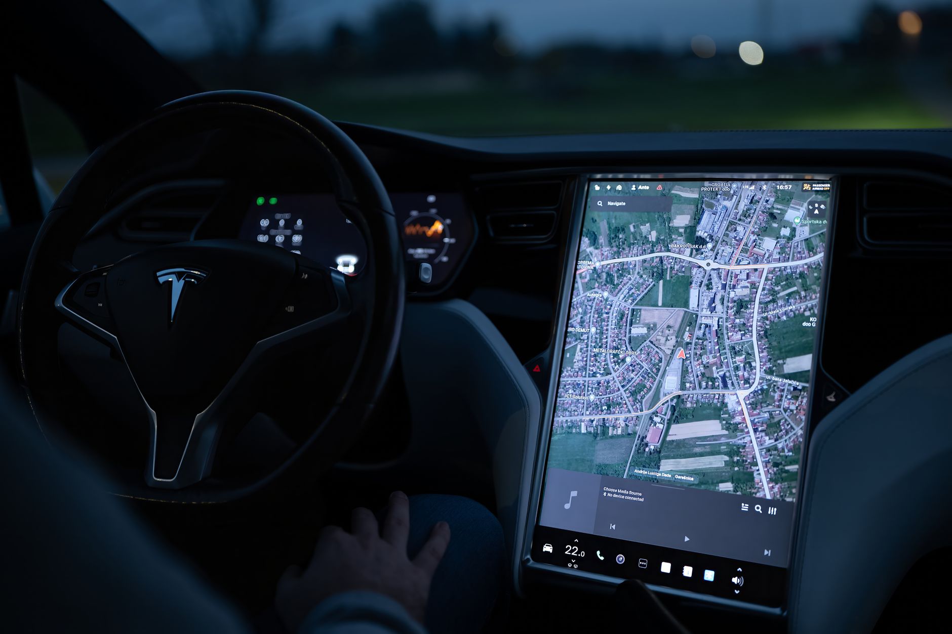 Nocne wnętrze elektrycznego auta z podświetlonym ekranem nawigacji