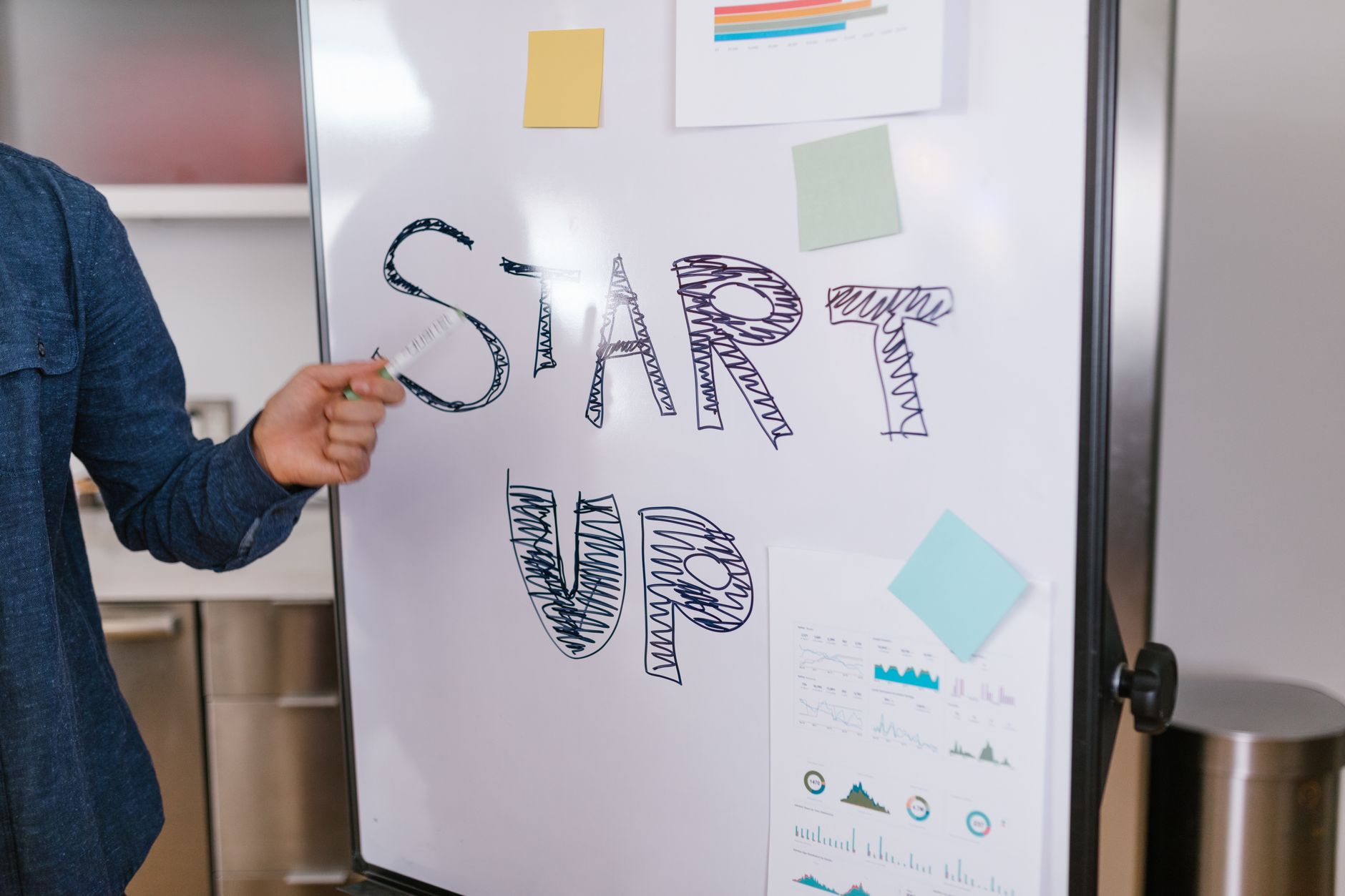 Osoba omawia pomysł startupu przy białej tablicy w biurze