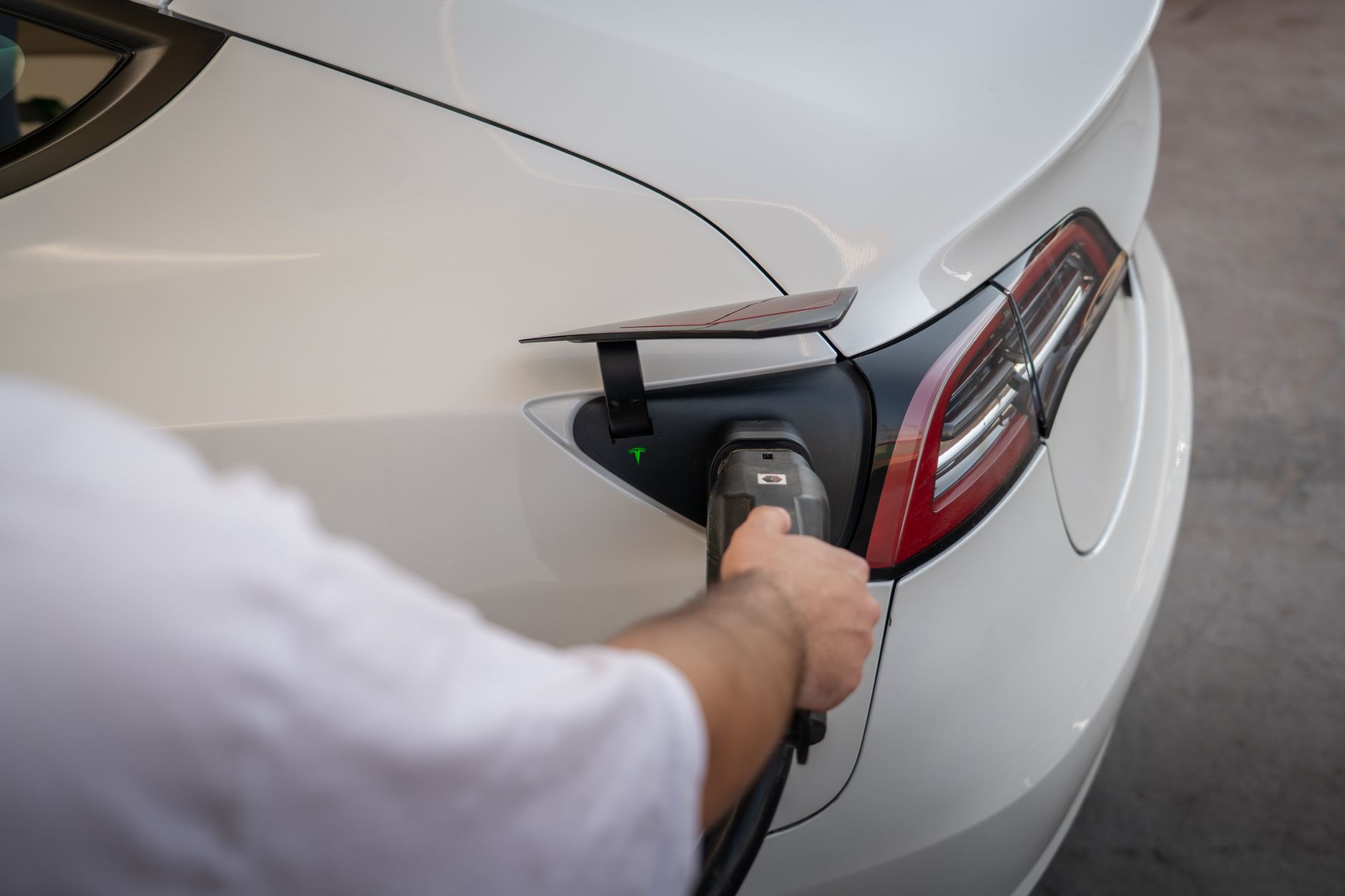 Zbliżenie na ładowany samochód elektryczny przy nowoczesnej stacji