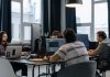 Zespół programistów pracujący przy komputerach w nowoczesnym biurze