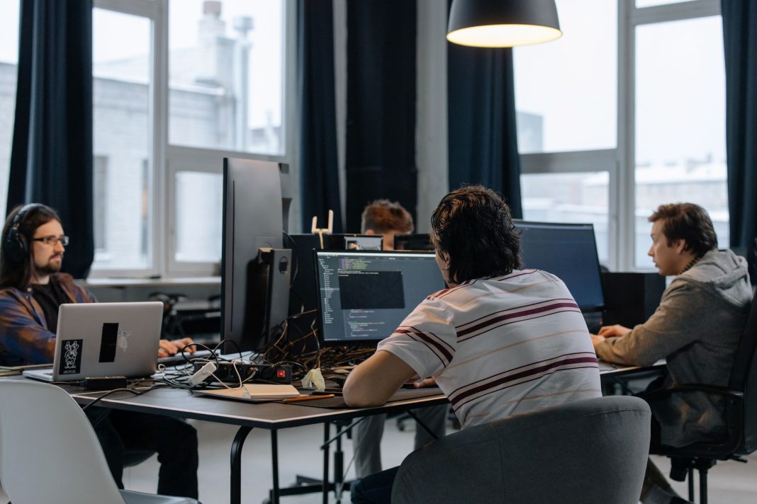 Zespół programistów pracujący przy komputerach w nowoczesnym biurze
